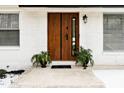 Modern wood front door with black accents and potted plants at 1128 E Geer St, Durham, NC 27704