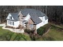 An aerial view of a house with stone and siding, a well-manicured lawn, and mature trees at 1201 Rivermead Ln, Wake Forest, NC 27587