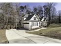 View of home featuring an attached garage, concrete driveway, manicured landscaping, and mature trees at 1201 Rivermead Ln, Wake Forest, NC 27587