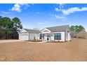 White two-story house with gray roof, large windows, and landscaping at 1647 Old Dam Rd, Kenly, NC 27542