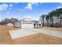 White house with three car garage and large driveway at 1647 Old Dam Rd, Kenly, NC 27542