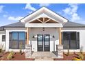 Modern farmhouse front entrance with double doors and stone accents at 1647 Old Dam Rd, Kenly, NC 27542