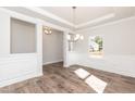 Bright dining room features elegant trim work, modern chandelier, and beautiful wood flooring at 237 Hopewell Branch Ct, Smithfield, NC 27577