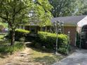 Charming brick home featuring a well-manicured front yard and a vintage lamppost at 2612 Academy St, Sanford, NC 27332