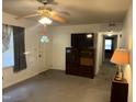 A cozy living room features neutral walls, a ceiling fan, and views into the hallway at 2612 Academy St, Sanford, NC 27332