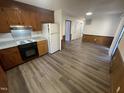 Kitchen with wood cabinets, granite countertops, and grey wood-look floors at 2801 O'Shanter Pl, Raleigh, NC 27604