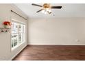 Bright living room featuring hardwood floors, a large window, and a ceiling fan at 30 Cheltenham Dr, Clayton, NC 27520