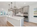 Modern kitchen with stainless steel appliances, quartz countertops, and stylish pendant lighting at 515 Wendover Pkwy, Pittsboro, NC 27312