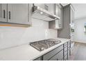 Close-up of a kitchen with stainless steel range hood and a white backsplash at 515 Wendover Pkwy, Pittsboro, NC 27312
