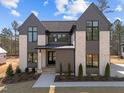 Two-story home featuring a modern design and a combination of brick and siding with manicured landscaping at 8001 Wexford Waters Ln, Wake Forest, NC 27587