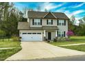 Attractive two-story home with two-car garage, well-kept lawn and blossoming tree at 105 Langdon Chase Way, Selma, NC 27576