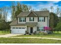 Charming two-story home with a two-car garage, landscaped yard and inviting front porch at 105 Langdon Chase Way, Selma, NC 27576