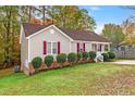 Tan house with red shutters and landscaping at 125 Havencrest Lndg, Garner, NC 27529