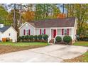 Tan house with red shutters, landscaping, and a red front door at 125 Havencrest Lndg, Garner, NC 27529