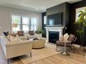 Cozy living room with a fireplace, large windows, comfortable seating, and a neutral color palette at 1364 Barreto Dr, Wendell, NC 27591