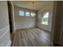 Bright dining room with wood-look floors, chandelier, wainscoting and natural light at 14 E American Marigold Dr # 65, Benson, NC 27504