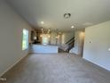 Open-concept living room and kitchen featuring modern lighting and neutral color palette at 14 E American Marigold Dr # 65, Benson, NC 27504