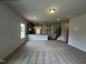 Bright and spacious living room with neutral carpeting, seamlessly connecting to kitchen and staircase at 14 E American Marigold Dr # 65, Benson, NC 27504
