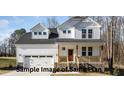 Two-story white house with stone accents, double garage, and a covered porch at 165 Tuskeegee Dr, Smithfield, NC 27577