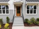 Modern front entry with gray brick, wood door, and a stone landing at 2404 Toll Mill Ct, Raleigh, NC 27606