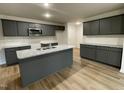 Modern kitchen with dark gray cabinets, granite countertops, and an island at 257 Magnolia Run Way, Benson, NC 27504