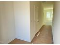 An interior view of a hallway with white walls and a closed white door, leading to a room with natural light at 340 Arch Canyon Cir, Zebulon, NC 27597