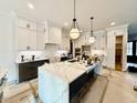 Modern kitchen featuring a large island and white cabinets at 75 Cherry Bark Dr, Youngsville, NC 27596