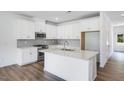 Well-lit kitchen features white cabinets, an island and stainless steel appliances at 8703 Wardle Ct, Wake Forest, NC 27587