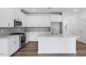 Modern kitchen with white cabinets, stainless steel appliances, and a large center island at 8703 Wardle Ct, Wake Forest, NC 27587