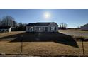 Newly constructed home with a gray exterior, landscaped yard, and driveway at 90 Faucette Dr, Selma, NC 27576