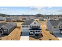 Aerial view of a two-story home in a suburban neighborhood with a spacious yard and blue skies at 107 Barn Door Dr, Lillington, NC 27546