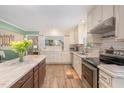 Bright kitchen with white cabinets, island with marble countertop, and stainless steel appliances at 112 Wagon Trl, Willow Springs, NC 27592