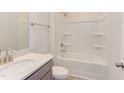 Bathroom with white bathtub, shower, and gray vanity at 121 Barn Door Dr, Lillington, NC 27546