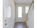 Bright entryway with white door, wood stairs, and laminate flooring at 128 Baird Cv Ln, Angier, NC 27501