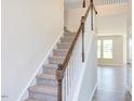 Wooden staircase with carpeted steps and a simple white railing at 141 Little Br Dr, Lillington, NC 27546