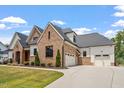 Brick and siding home with three car garage and a large driveway at 1505 Montvale Grant Way, Cary, NC 27519