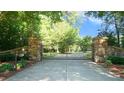 Stone pillars and wrought iron gates lead to the estate at 15508 Possum Track Rd, Raleigh, NC 27614