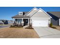 Charming craftsman style home with a two-car garage and rocking chairs on the front porch at 1626 Plover Cir, Fuquay Varina, NC 27526