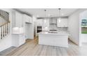 Modern white kitchen with a large island, stainless steel appliances, and stylish pendant lighting at 1705 Clydner Dr, Cary, NC 27523