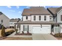 Two-story townhome with gray siding, white garage door, and landscaping at 3200 Retama, New Hill, NC 27562