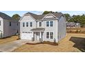 Two-story house with gray siding, white garage doors, and landscaping at 34 Windflower Ct, Clayton, NC 27520