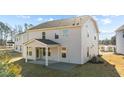 Back of home showing covered porch and lawn at 34 Windflower Ct, Clayton, NC 27520