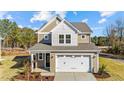 Two-story house with beige siding, white trim, and a two-car garage at 36 Railcar Way, Clayton, NC 27520