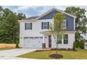 Two-story house with white and blue siding, a two-car garage, and a landscaped lawn at 37 Baird Cv Ln, Angier, NC 27501