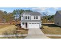 Attractive two-story home showcasing a gray exterior, landscaped front yard, and an attached two-car garage at 48 Railcar Way, Clayton, NC 27520
