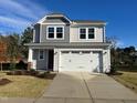 Beautiful gray two-story home with a two-car garage and a well-manicured front lawn at 48 Railcar Way, Clayton, NC 27520