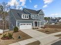 A charming two-story home showcases blue siding, a two-car garage, and meticulous landscaping at 645 Silvercomet Dr, Knightdale, NC 27545