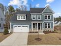 Charming two-story home featuring blue siding, stone accents, and a well-maintained lawn at 645 Silvercomet Dr, Knightdale, NC 27545