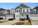 Two-story townhome with gray and white siding, two-car garage, and landscaping at 747 Creekway Dr, Fuquay Varina, NC 27526