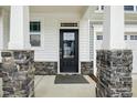 Modern black front door with glass panels and stone accents at 747 Creekway Dr, Fuquay Varina, NC 27526